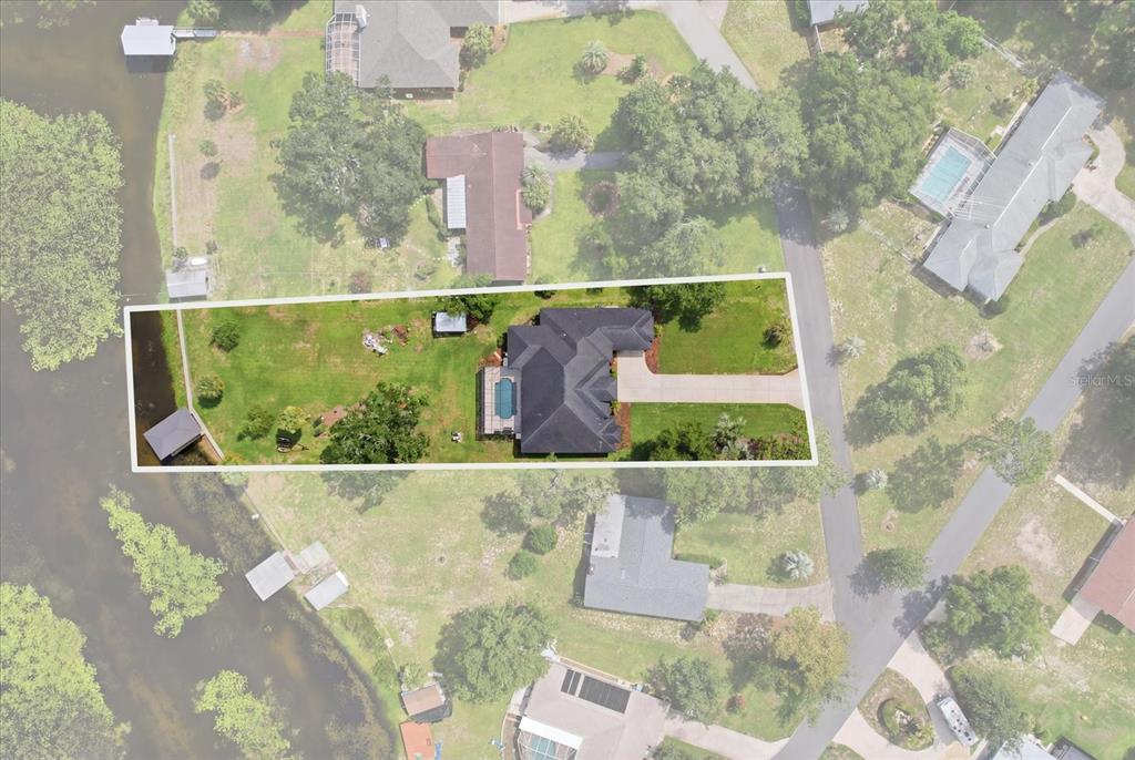 This aerial view shows a house with a pool and dock on a large lot — 3028 S DAVIS LAKE DRIVE, INVERNESS, FL