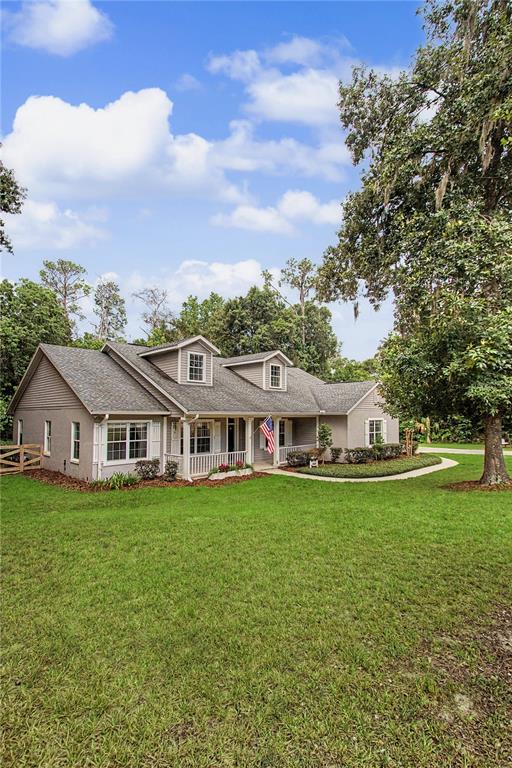 A single-story gray house with a front porch and dormer windows sits on a lawn — 5045 SW 2ND AVENUE, OCALA, FL