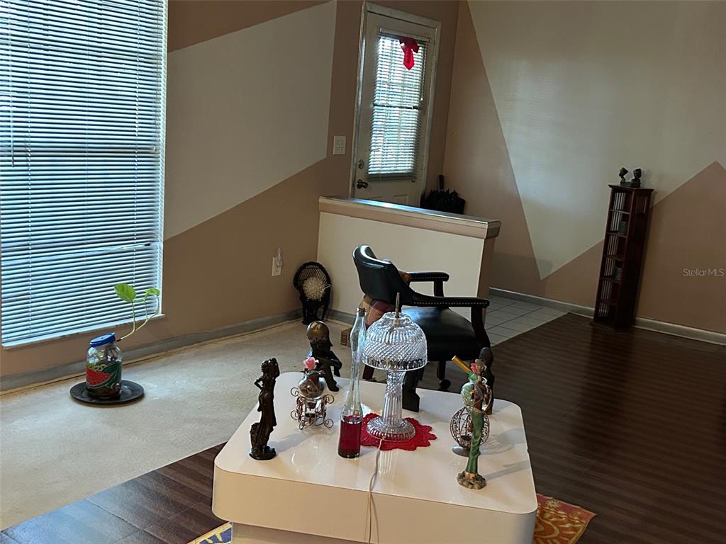 A living room features a white coffee table, a black chair, and two-toned wall paint — 2932 SILVER RIDGE DRIVE, ORLANDO, FL