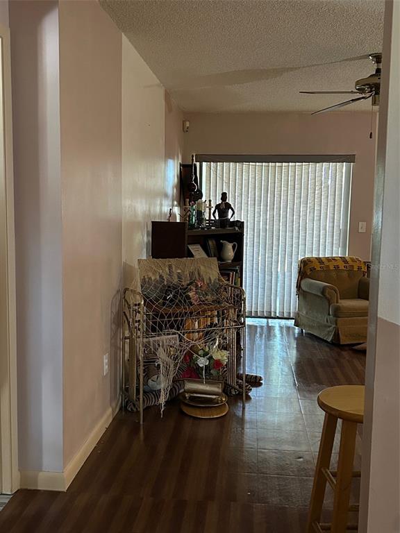 A living room features wood-look flooring, a ceiling fan, a bookshelf, and a tan armchair — 2932 SILVER RIDGE DRIVE, ORLANDO, FL