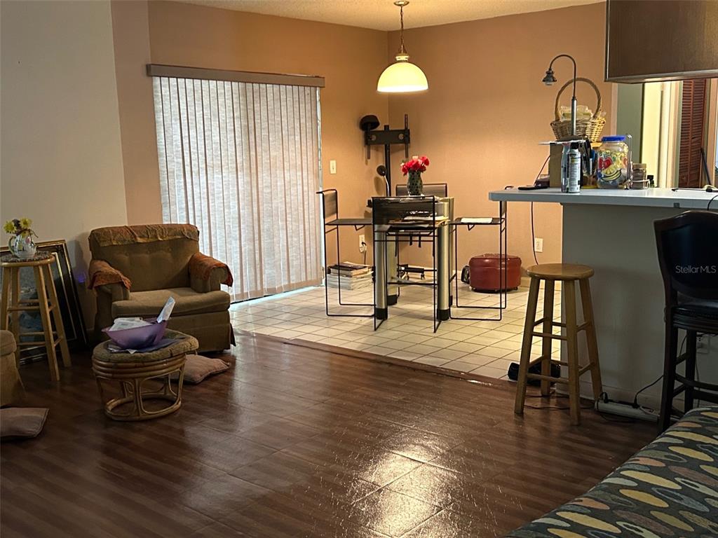 A living and dining area features wood-look flooring, tiled dining space, and a breakfast bar — 2932 SILVER RIDGE DRIVE, ORLANDO, FL