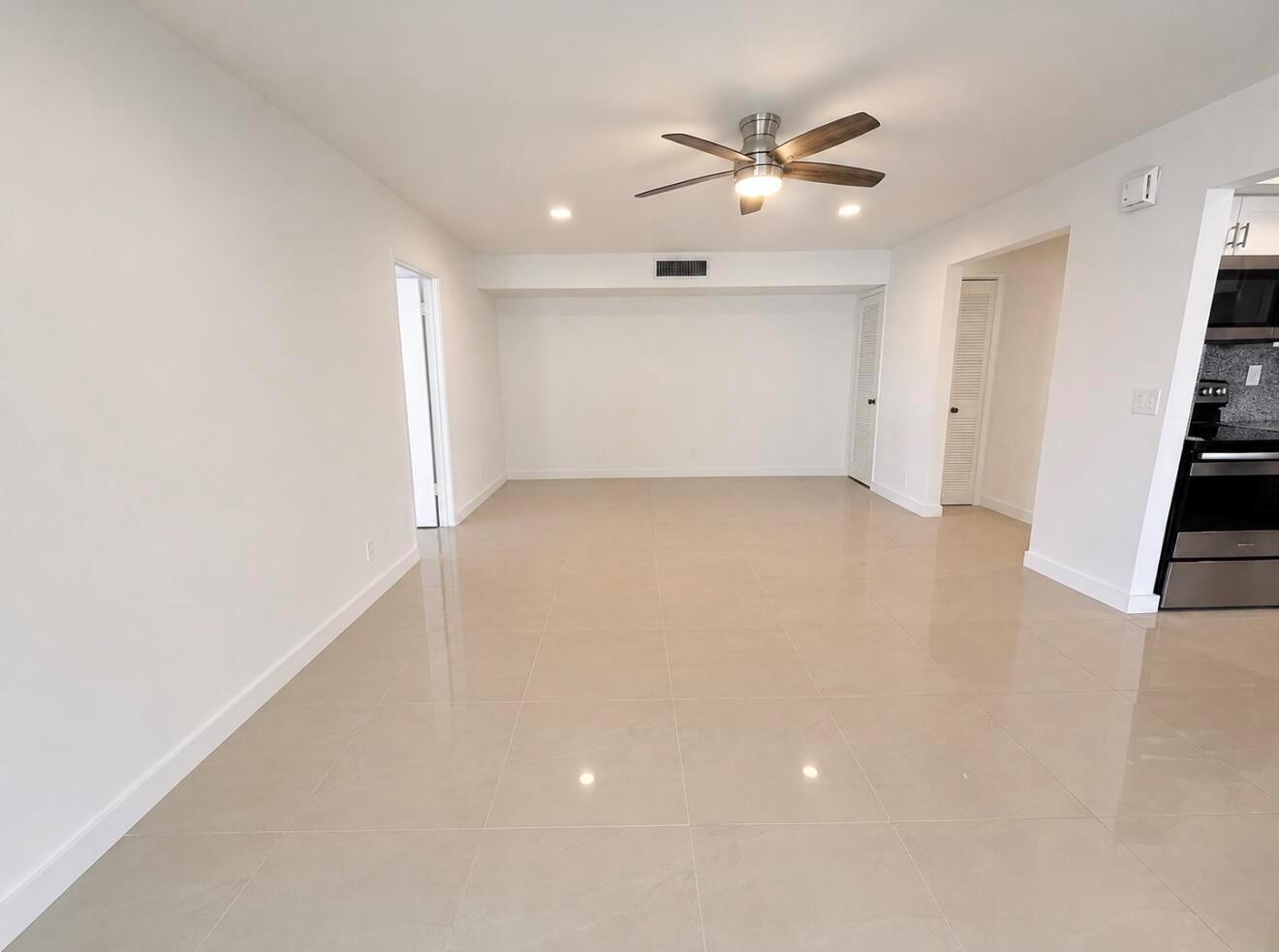 An empty room with white walls, a ceiling fan, and light-colored tile flooring — 514 Piedmont K, Delray Beach FL 33446, DELRAY BEACH, FL