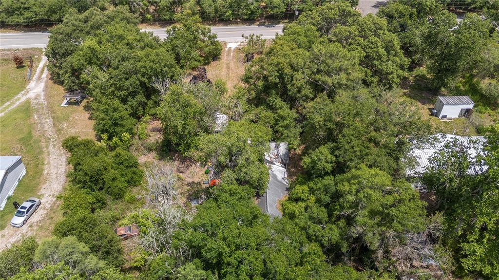 An aerial view shows a wooded property with a house, outbuildings, and a gravel driveway — 12614 ROCKRIDGE ROAD, LAKELAND, FL