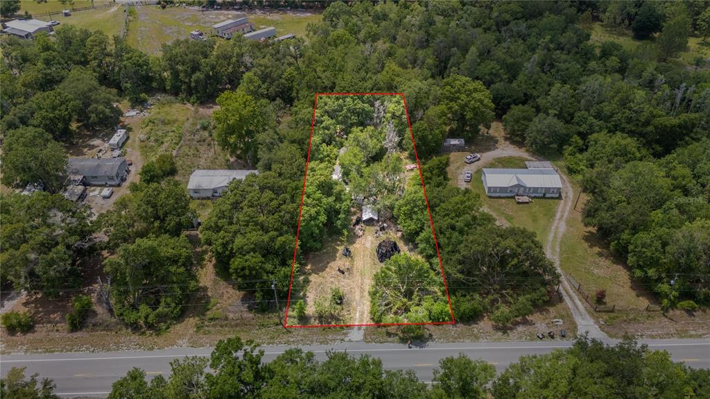An aerial view shows a rectangular lot outlined in red containing trees and structures — 12614 ROCKRIDGE ROAD, LAKELAND, FL