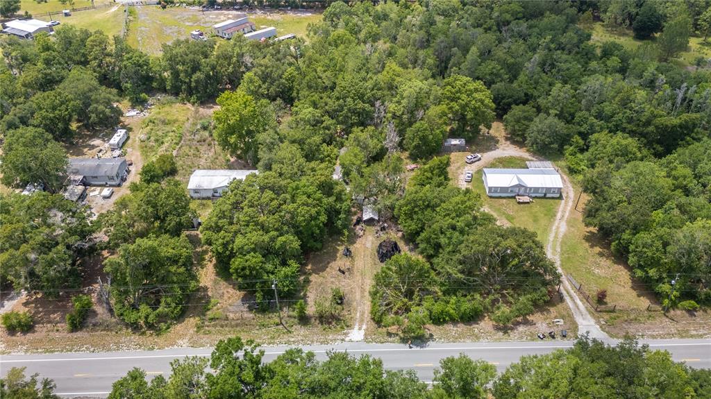 An aerial view shows several houses and outbuildings situated on a wooded, rural property — 12614 ROCKRIDGE ROAD, LAKELAND, FL