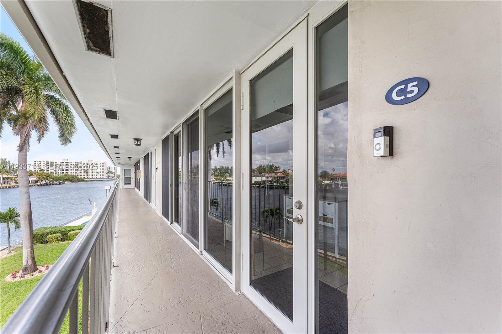 A waterfront balcony features glass doors, a doorbell camera, and a unit number sign — 743 N Riverside Dr # 5C, Pompano Beach FL 33062, POMPANO BEACH, FL