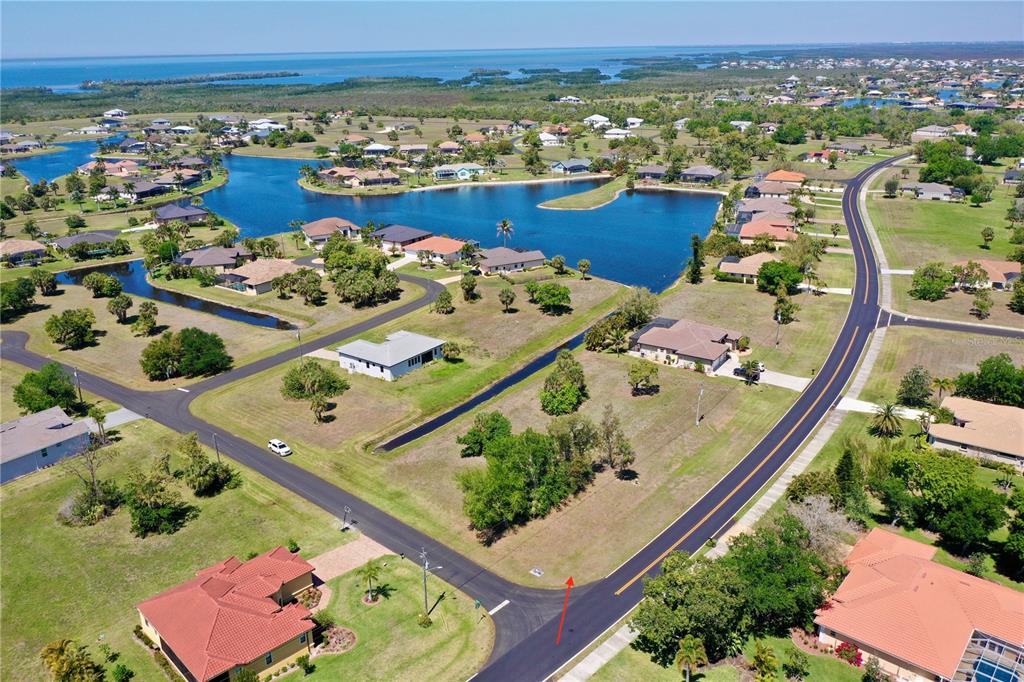 An aerial view shows a vacant residential lot situated between two paved roads near water — 17175 CAPE HORN BOULEVARD, PUNTA GORDA, FL
