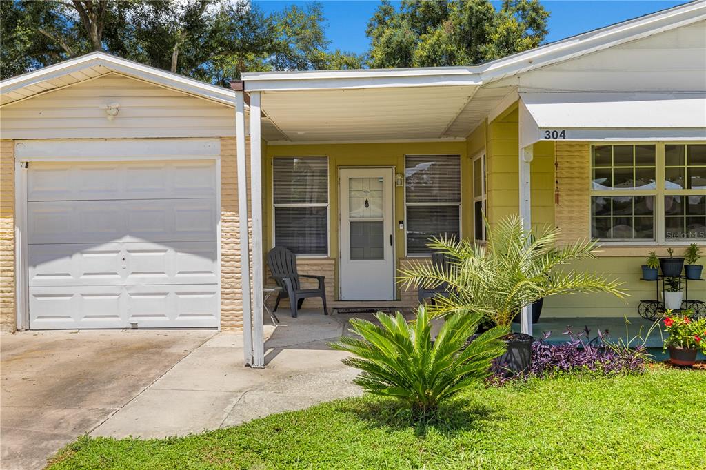 A single-story house exterior features a garage, a covered porch, and a small front yard — 304 W LAKE AVENUE, AUBURNDALE, FL
