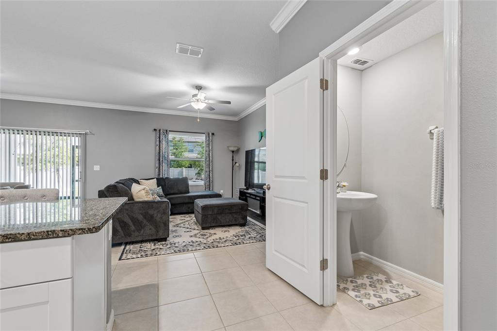 A view from a kitchen area looking into a living room and a small bathroom — 21851 LYONIA LANE, LAND O LAKES, FL