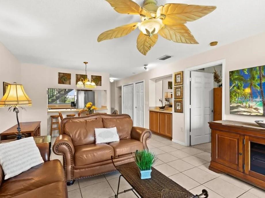 A living room with tile floors, a leather sofa, and a tropical-style ceiling fan — 1669 SEASCAPE CIRCLE UNIT 1669, TARPON SPRINGS, FL