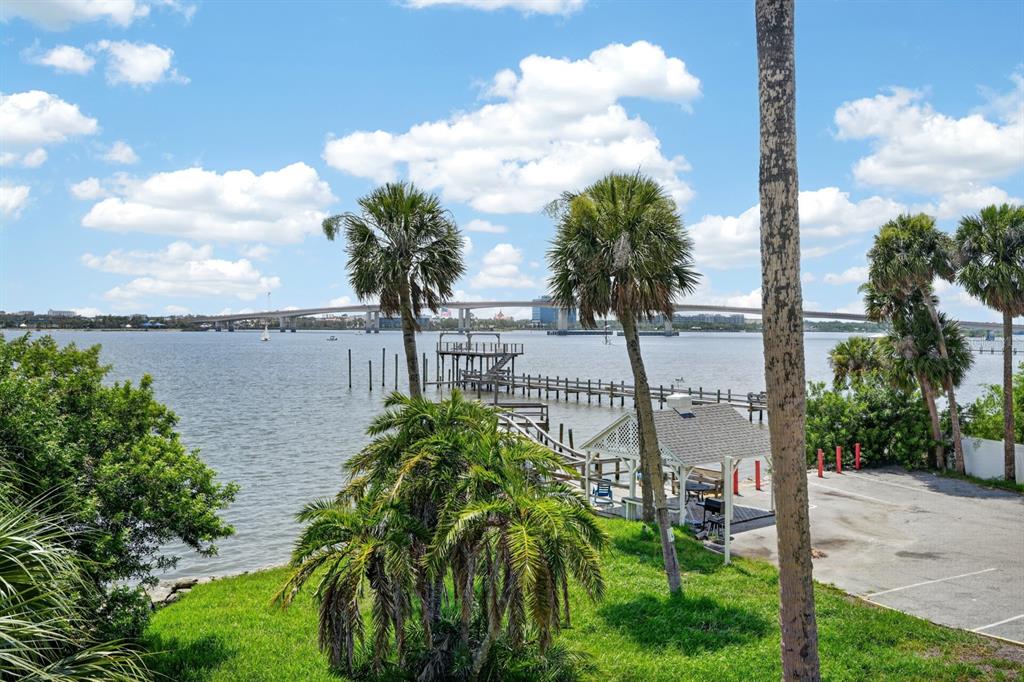 A view of a waterfront area with a pier, gazebo, palm trees, and a bridge — 900 S PENINSULA DRIVE UNIT 214, DAYTONA BEACH, FL
