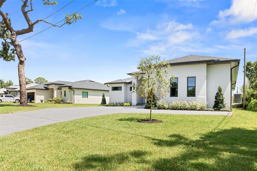 A modern white house with a gray roof and a large concrete driveway — 1336 HAYS ROAD, TARPON SPRINGS, FL