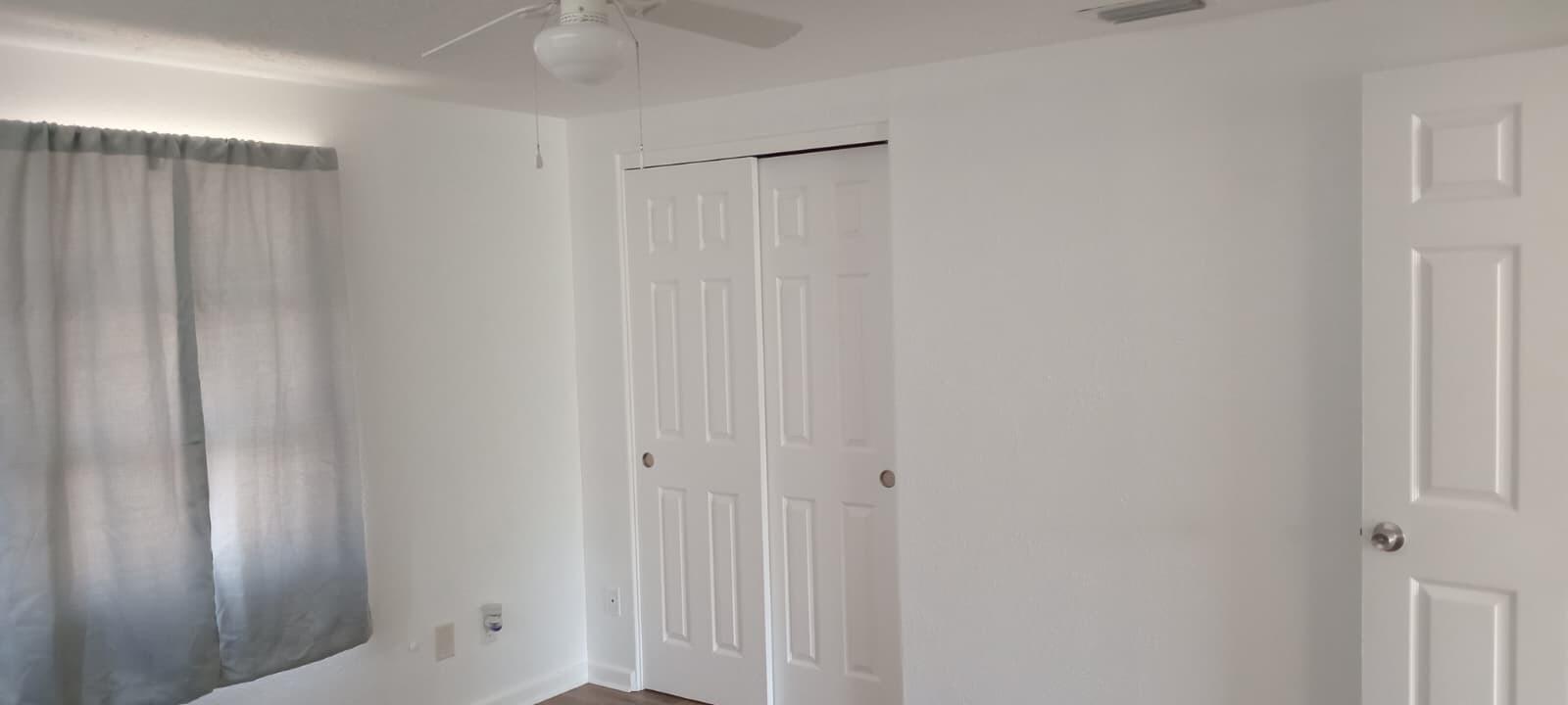 A bedroom featuring white walls, a ceiling fan, a closet with double doors, and curtains — 131 E Camphor Street, FL 33825, FL