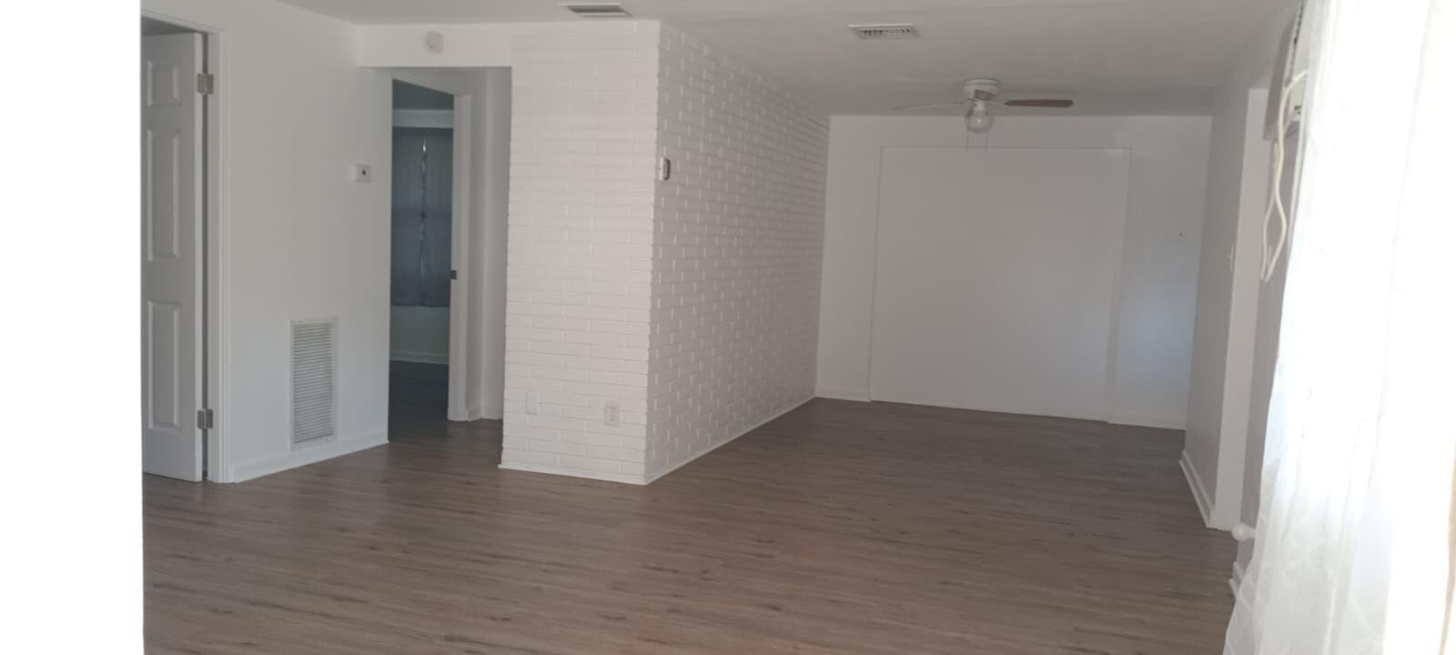 An empty room with light wood-look flooring, white walls, and a white painted brick pillar — 131 E Camphor Street, FL 33825, FL