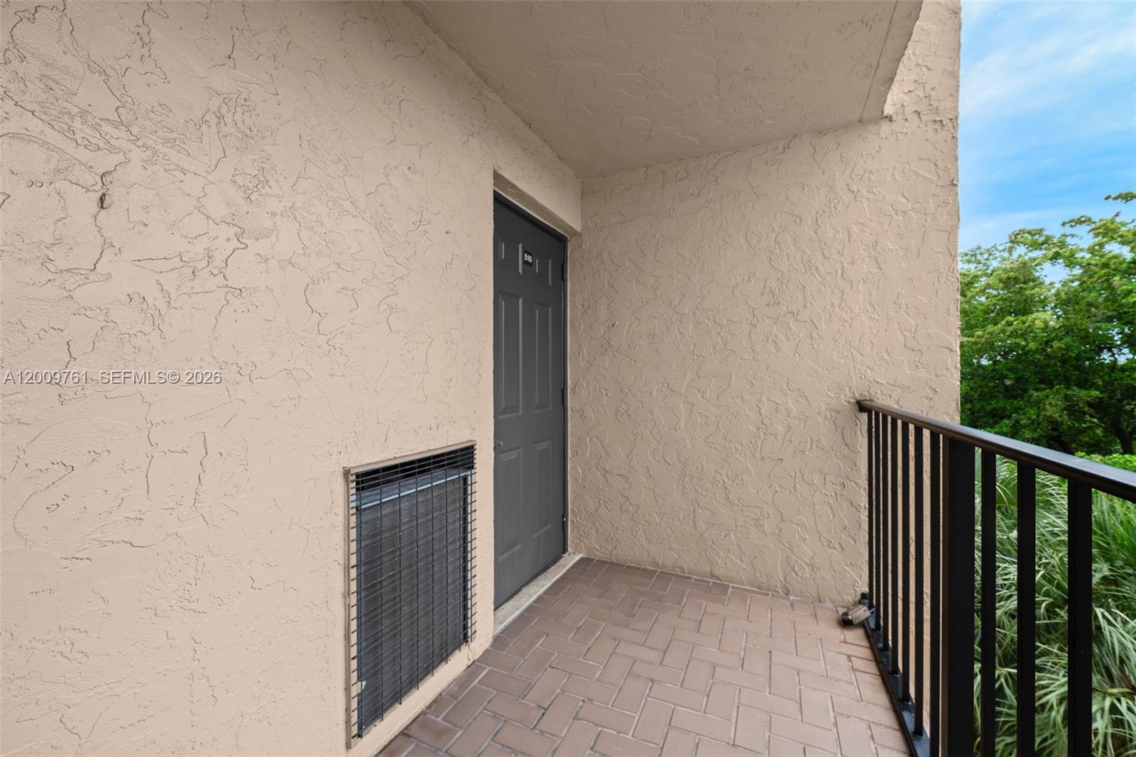 A balcony features a gray door, a metal HVAC vent, and a black railing — 3300 W Rolling Hills Cir # 510, Davie FL 33328, DAVIE, FL
