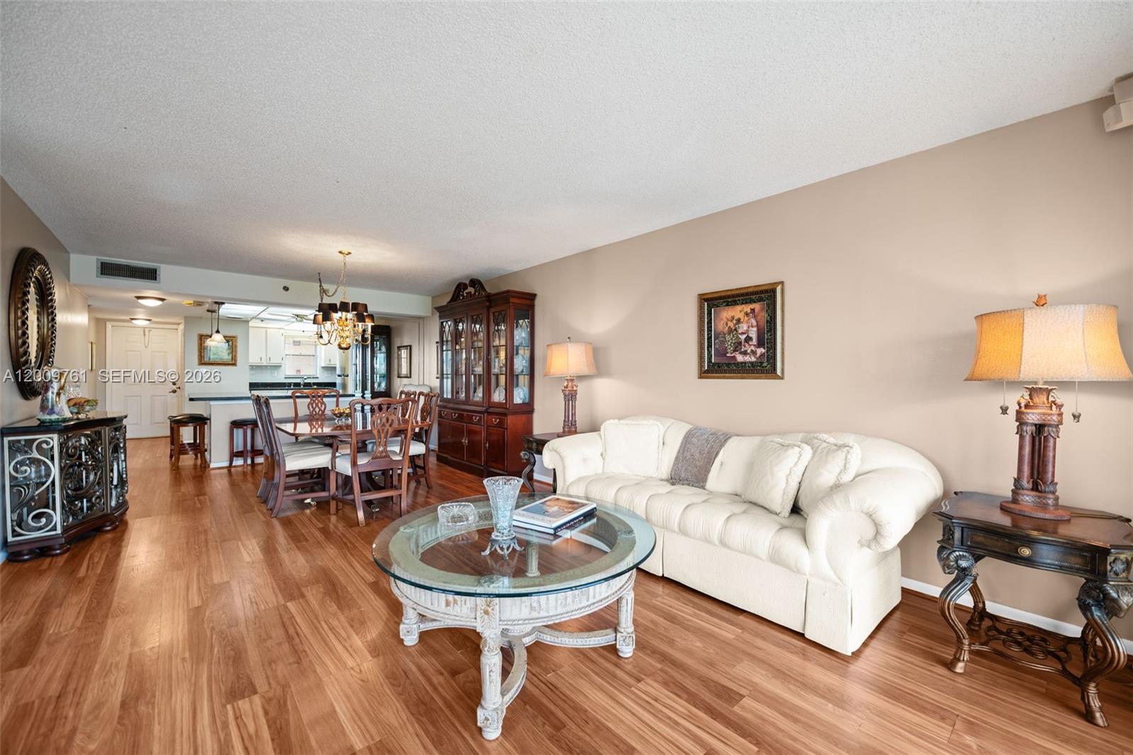 A living room and dining area feature wood flooring, a white sofa, and a hutch — 3300 W Rolling Hills Cir # 510, Davie FL 33328, DAVIE, FL