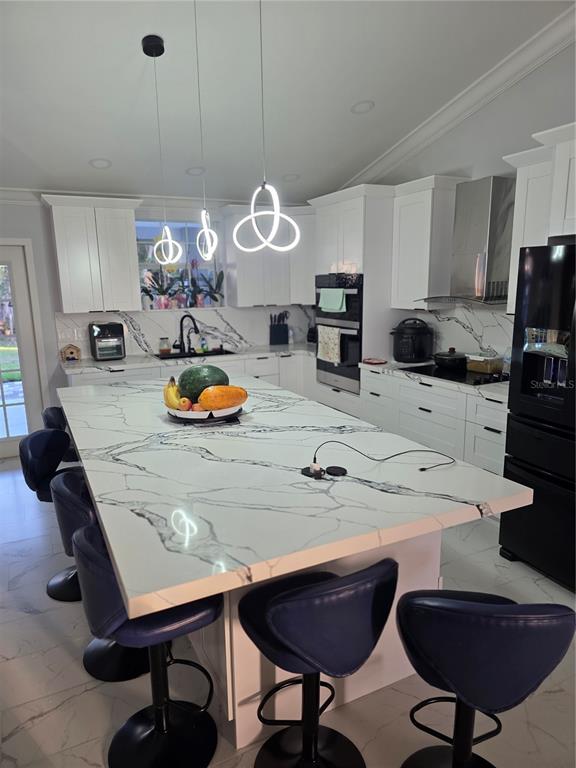 A modern kitchen features a large marble-topped island, white cabinetry, and dark blue bar stools — 3620 COUNTY ROAD 64 E, AVON PARK, FL
