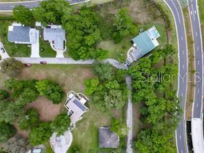 This aerial view shows several houses surrounded by trees near a curved road — LOT 52 BLK C LEXINGTON- CIRCLE, WILDWOOD, FL