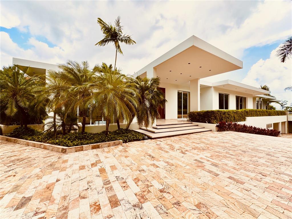 A modern white house features a large stone-paved driveway and several palm trees — URB. LA LOMITA CALLE VISTA LINDA, GUAYNABO, PR