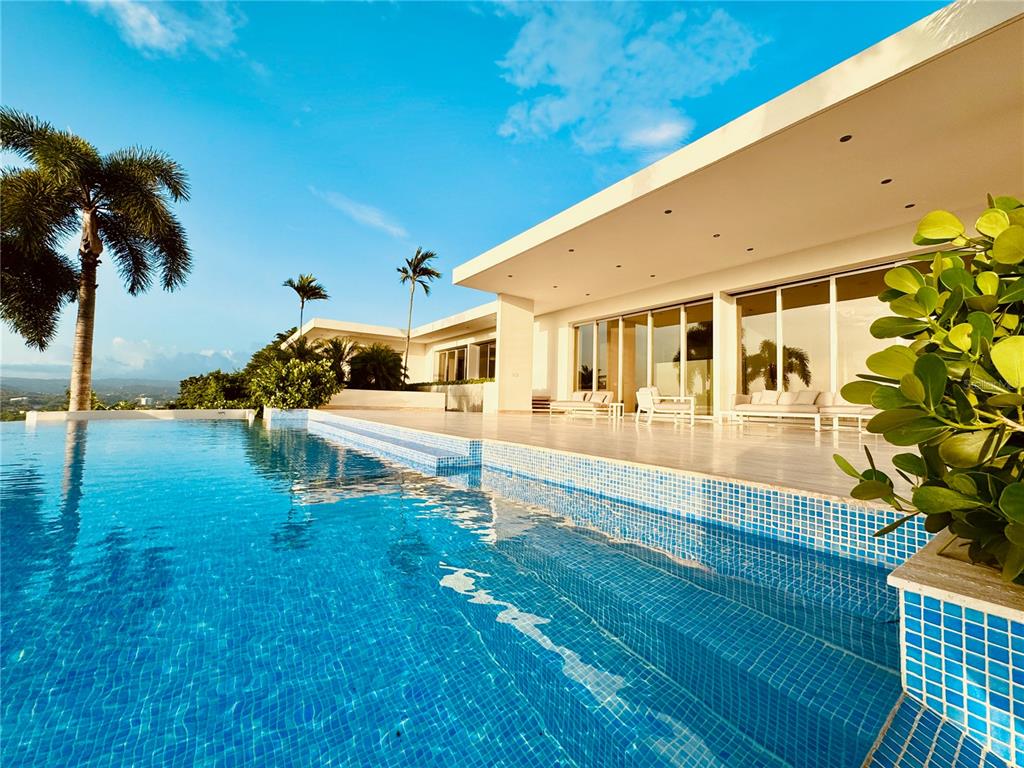 A modern house with a tiled patio and infinity pool overlooking a distant landscape — URB. LA LOMITA CALLE VISTA LINDA, GUAYNABO, PR