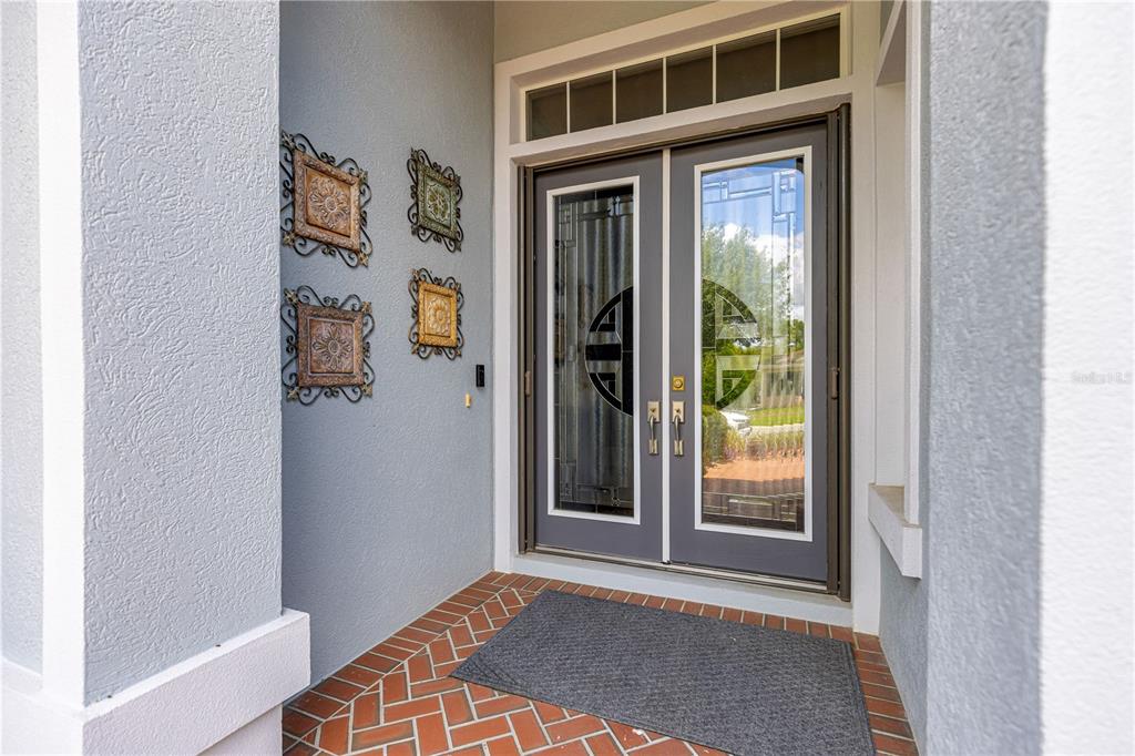 A front entryway features double glass doors, a brick floor, and decorative wall hangings — 9280 SE 126TH STREET, SUMMERFIELD, FL