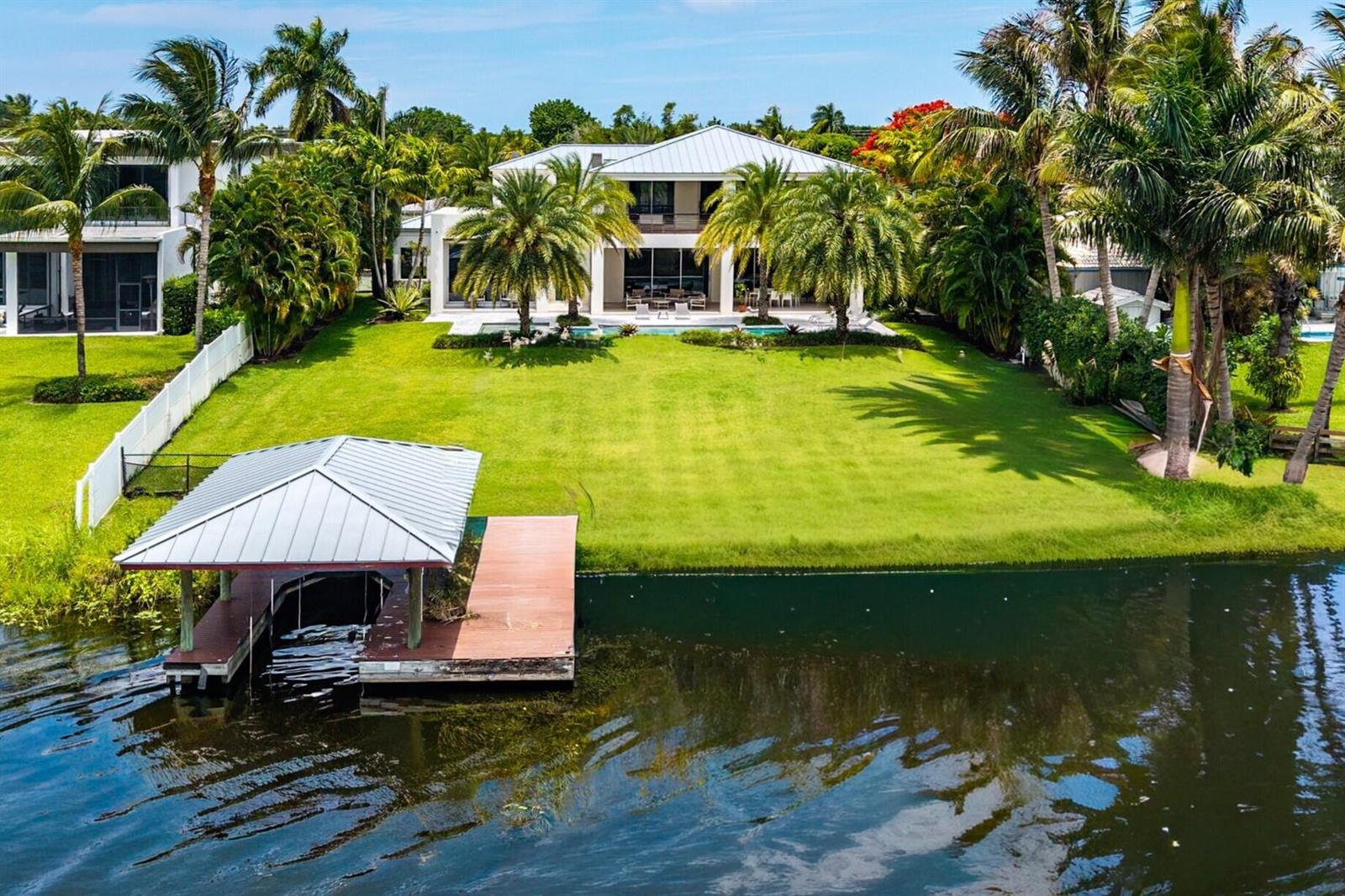 An aerial view of a waterfront house with a large lawn and a boat dock — 1508 Lake Drive, Delray Beach FL 33444, DELRAY BEACH, FL