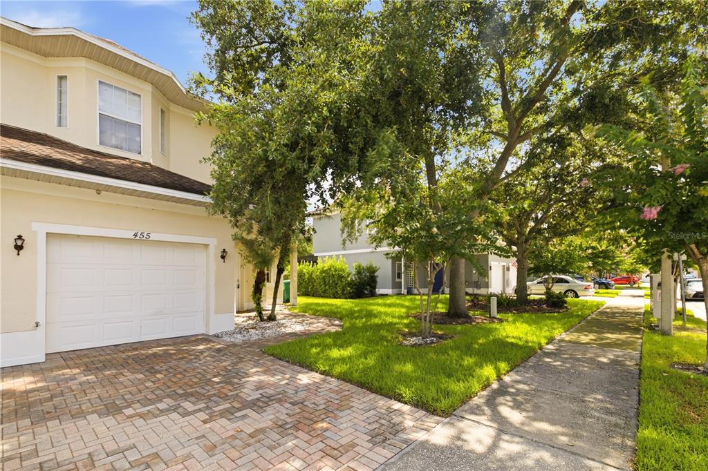 A two-story house with a white garage door, brick driveway, and trees in the front yard — 455 WESTPOINT GARDEN CIRCLE, WINTER GARDEN, FL