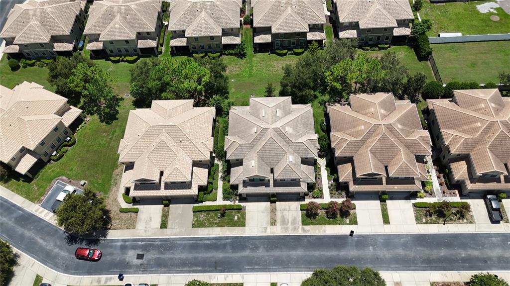 An aerial view shows several multi-story residential houses with tiled roofs along a paved street — 8240 ACADIAN LANE, SEMINOLE, FL