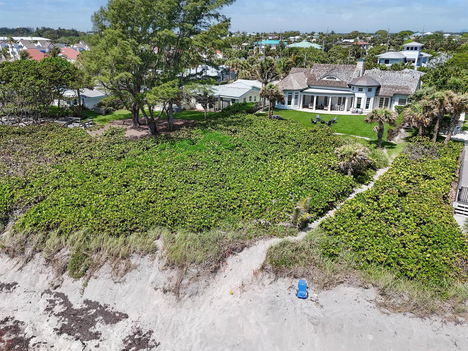 An aerial view shows a coastal home with a large lawn and private beach access — 282 Celestial Way, Juno Beach FL 33408, JUNO BEACH, FL