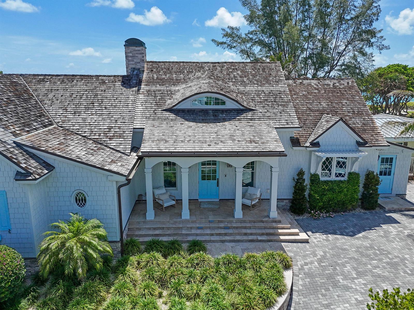 An aerial view of a shingled house with a blue front door and arched porch — 282 Celestial Way, Juno Beach FL 33408, JUNO BEACH, FL