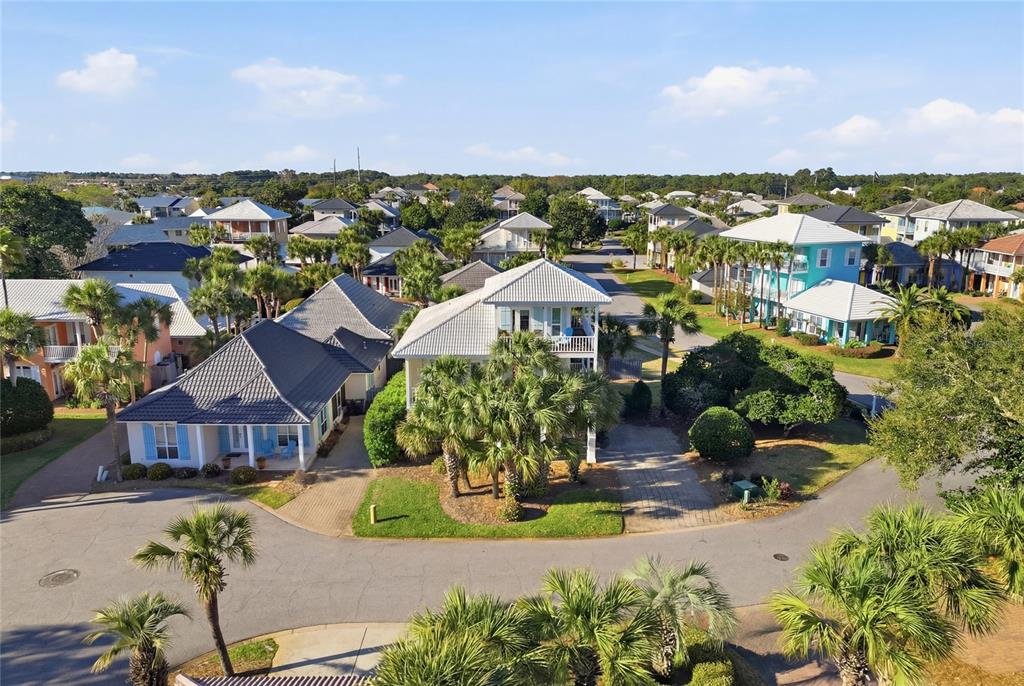 An aerial view shows several coastal-style houses with palm trees and paved driveways — 26 TOPAZ COVE, MIRAMAR BEACH, FL