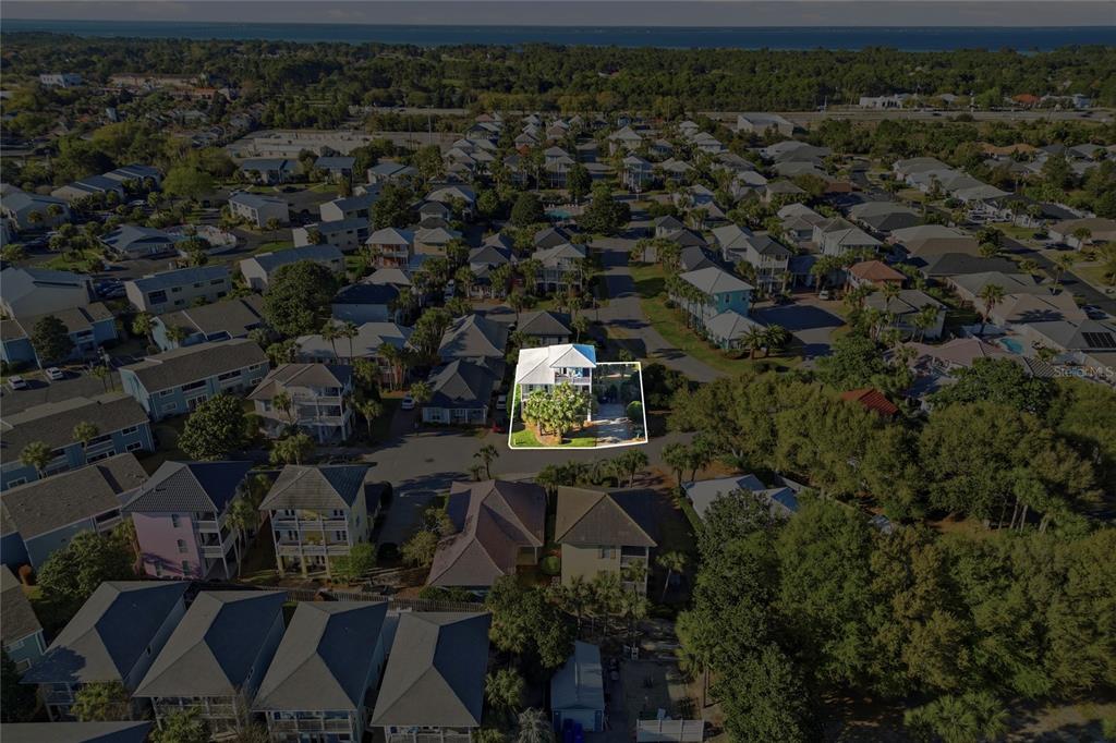 An aerial view shows a white house highlighted in a neighborhood near the coast — 26 TOPAZ COVE, MIRAMAR BEACH, FL