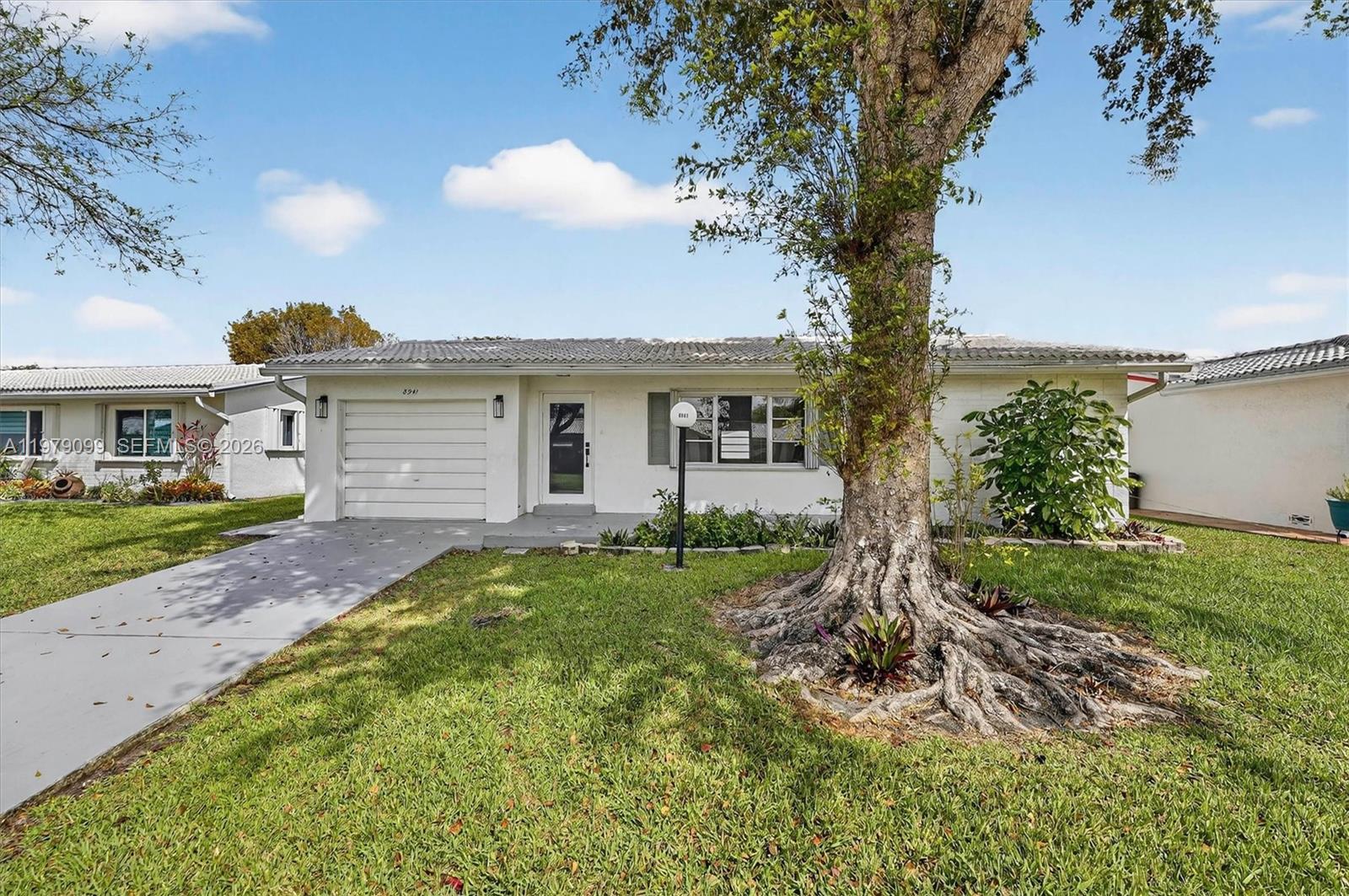 A single-story white house with a garage, a front lawn, and a large tree — 8941 NW 13th St, Plantation FL 33322, PLANTATION, FL