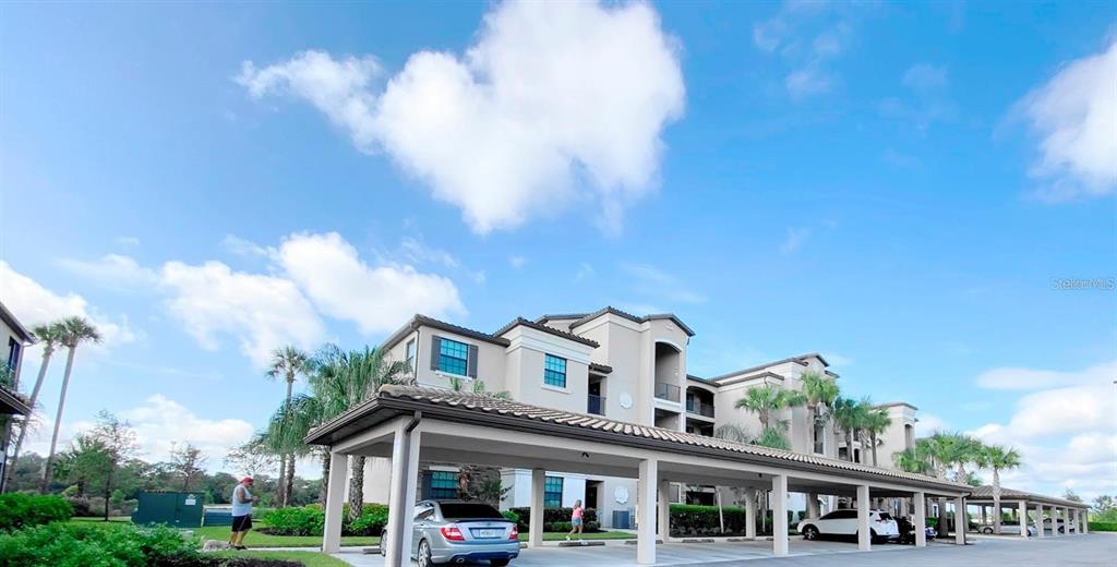A multi-story apartment building features a covered parking structure in the foreground — 16706 VARDON TERRACE UNIT 304, BRADENTON, FL
