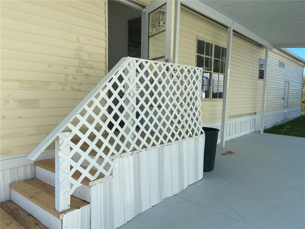 A set of wooden stairs with white lattice railings leads to the entrance of a home — 2008 HICKORYWOOD DRIVE, SOUTH DAYTONA, FL
