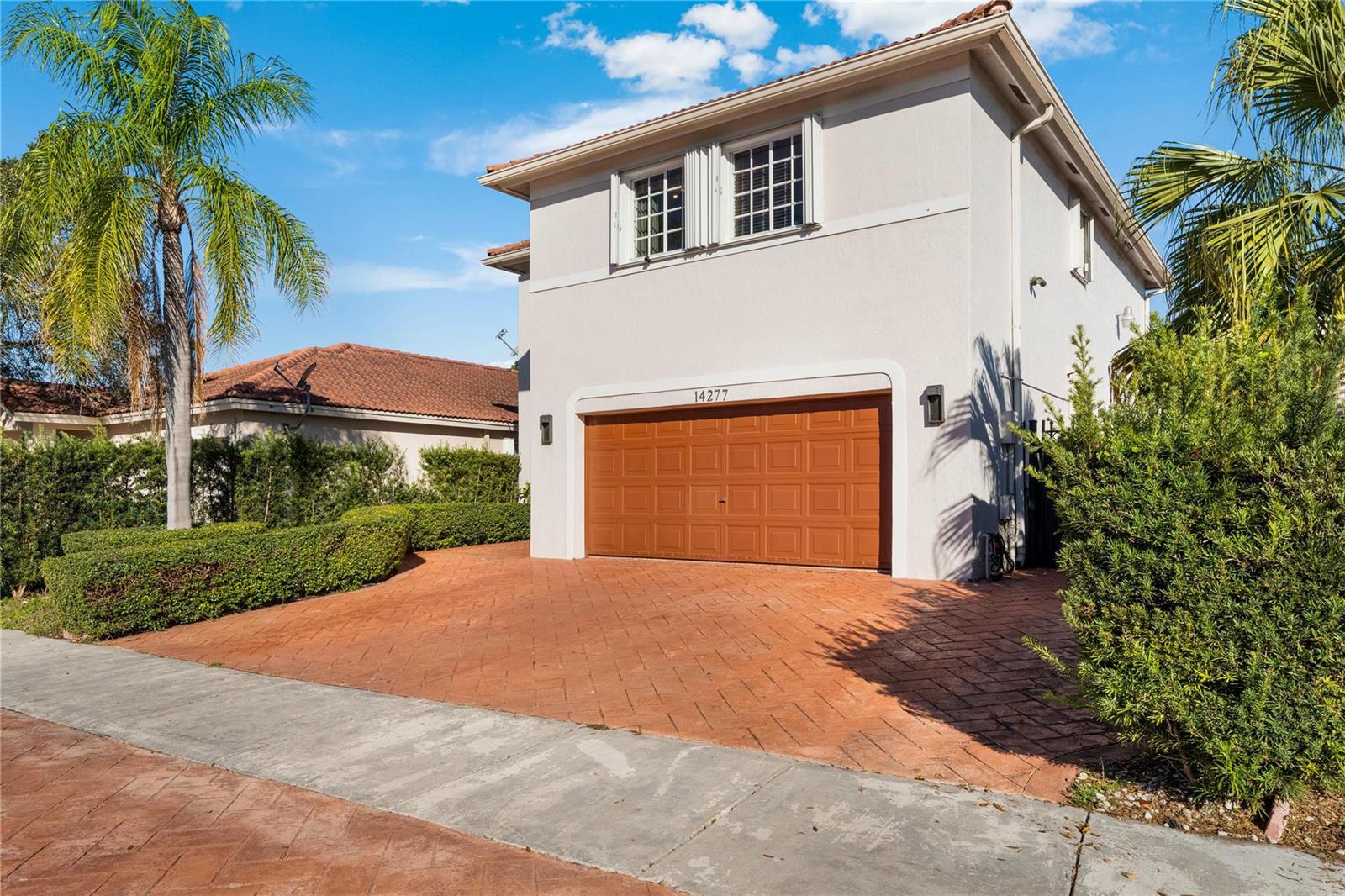 A two-story house with a brown garage door and a paved driveway at sunset — 14277 SW 177th Street, Miami FL 33177, MIAMI, FL