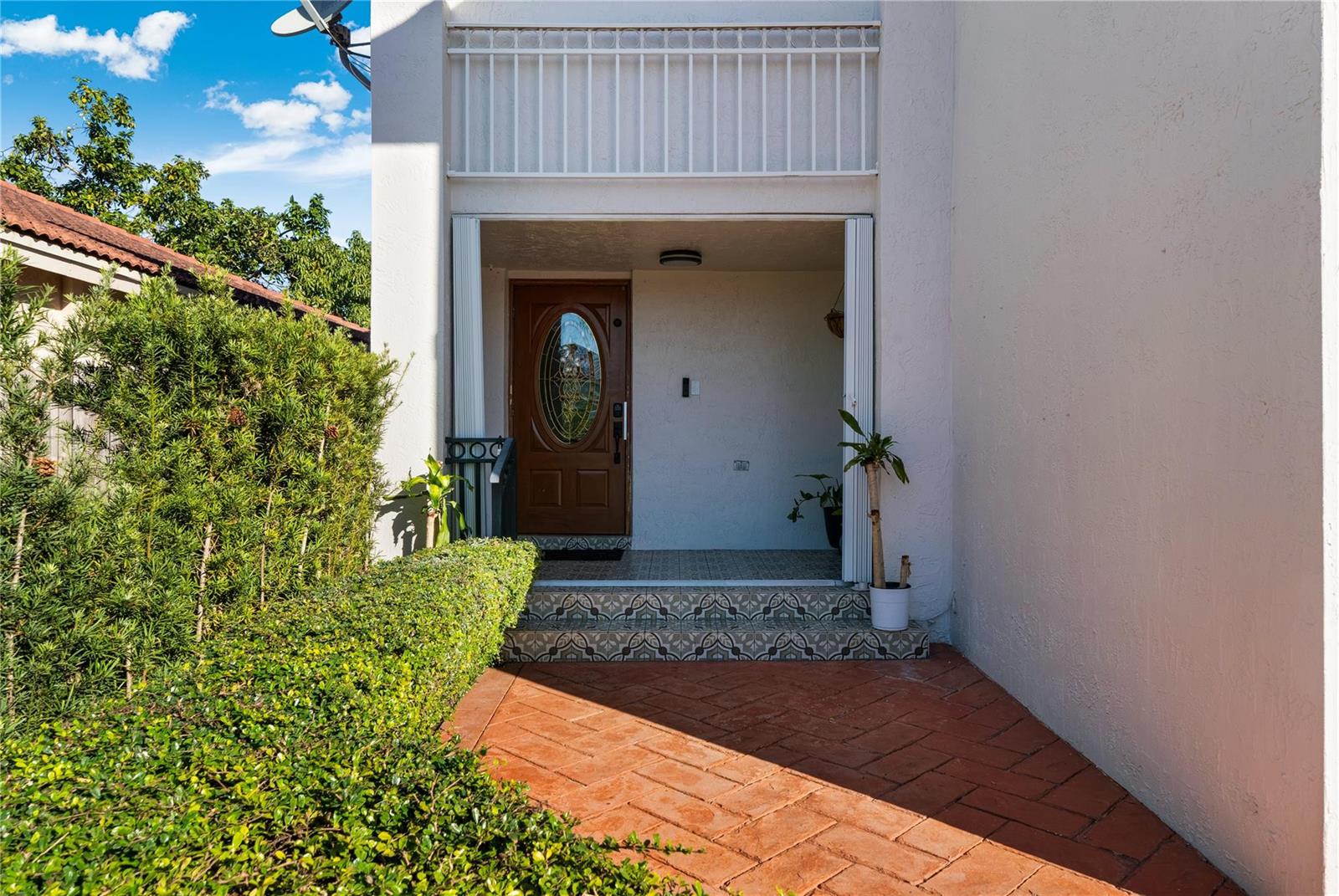 A paved patio features a large wooden pergola with integrated lighting and a covered grill — 14277 SW 177th Street, Miami FL 33177, MIAMI, FL