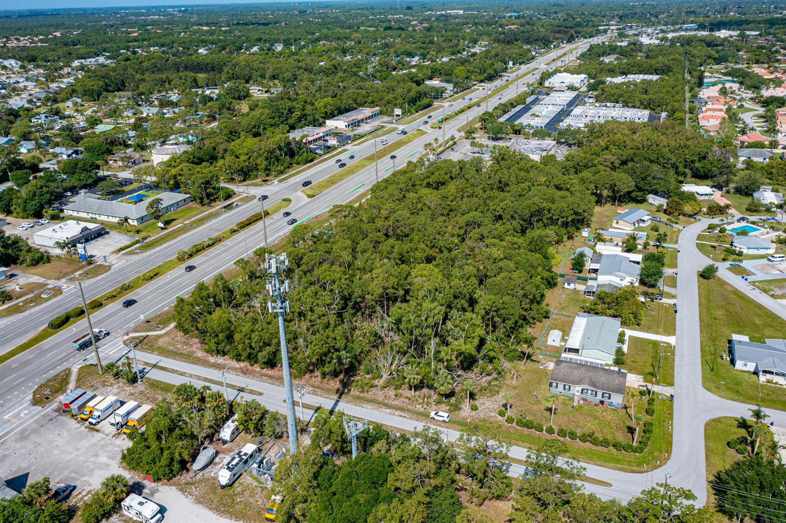 An aerial view shows a cell tower, a wooded lot, and a multi-lane highway — 0 SE Federal Highway, Stuart FL 34997, STUART, FL