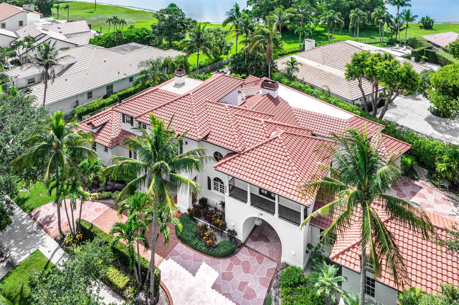An aerial view of a white Mediterranean-style house with a red tile roof and palm trees — 2 Firestone Circle, West Palm Beach FL 33401, WEST PALM BEACH, FL