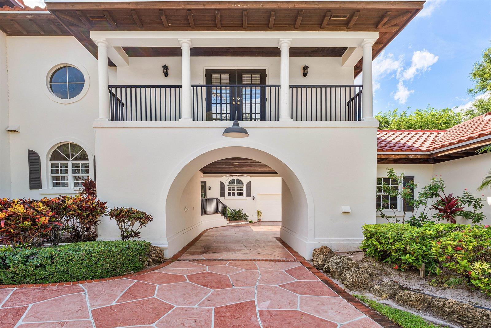 A white stucco house features a large arched porte-cochère with a balcony above — 2 Firestone Circle, West Palm Beach FL 33401, WEST PALM BEACH, FL
