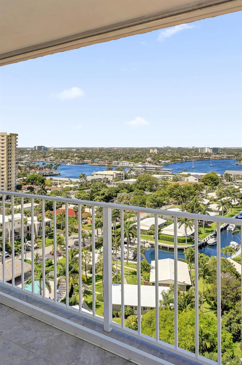 A high-angle view from a balcony overlooking a canal, residential neighborhood, and distant bay — 1010 S Ocean Boulevard # 2009, Pompano Beach FL 33062, POMPANO BEACH, FL