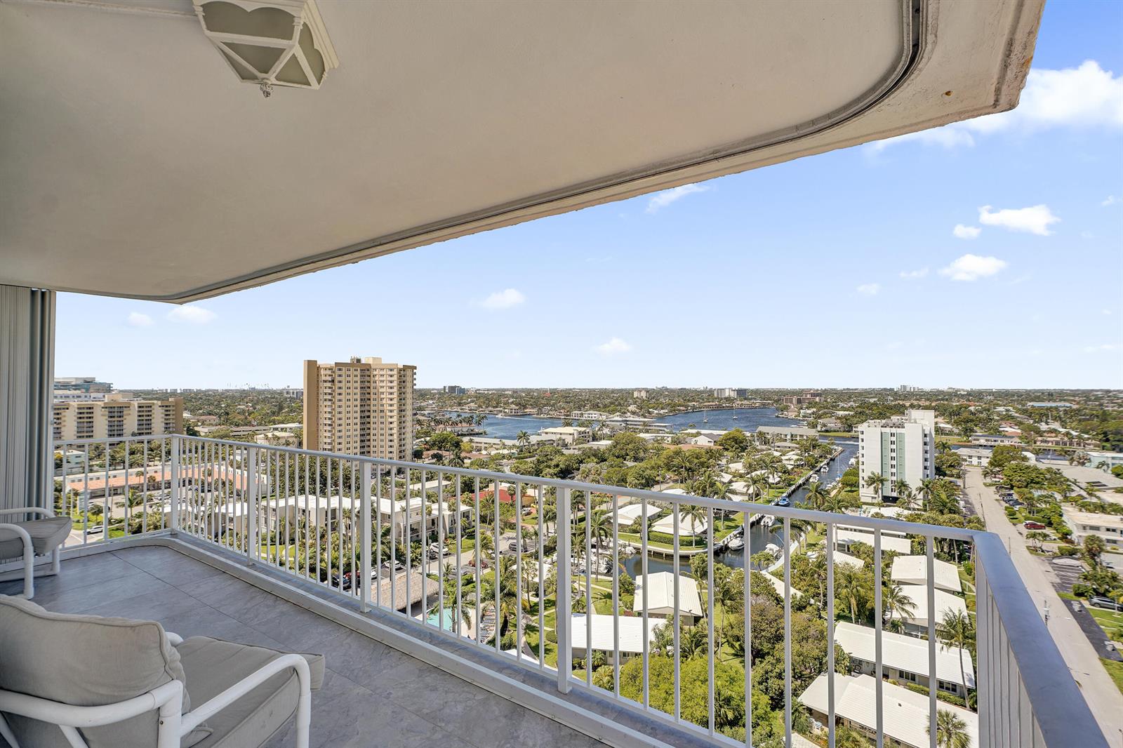 A high-rise balcony with white railings overlooks a suburban landscape, waterways, and distant buildings — 1010 S Ocean Boulevard # 2009, Pompano Beach FL 33062, POMPANO BEACH, FL