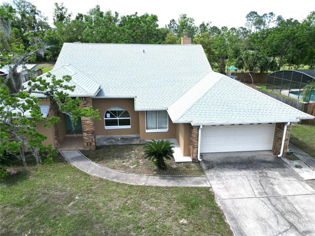An aerial view of a single-story house with a light-colored roof and a two-car garage — 4649 CREEKVIEW LANE, OVIEDO, FL