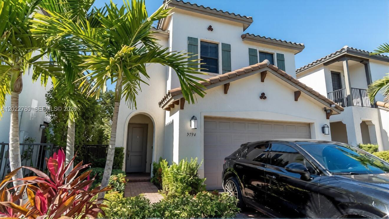 A two-story stucco house with a tile roof, a one-car garage, and a palm tree — 9794 W 34th Ct # 0, Hialeah FL 33018, HIALEAH, FL