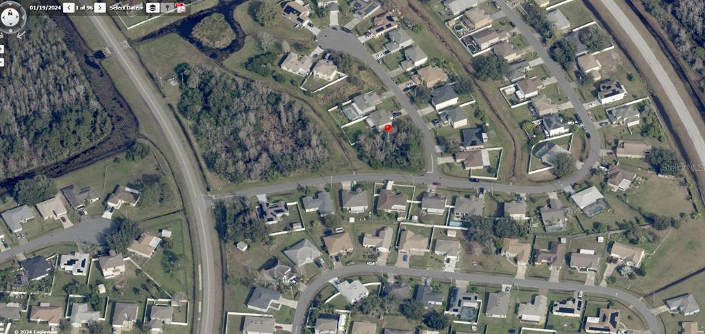 This aerial view shows a residential neighborhood with houses, streets, and wooded areas — 0 NOTRE DAME WAY, KISSIMMEE, FL