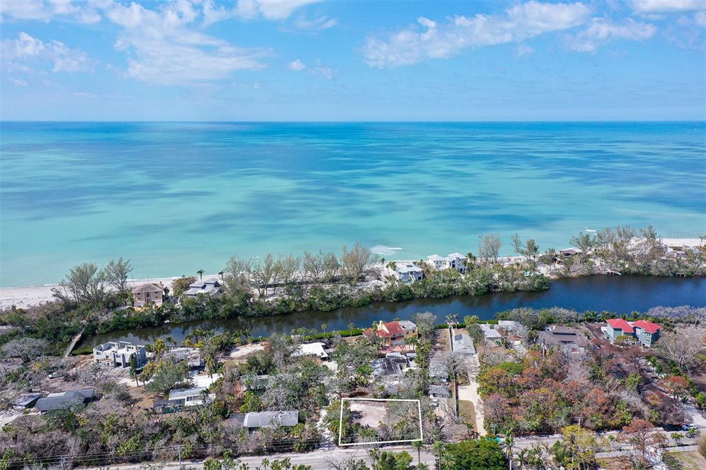 An aerial view shows a vacant, rectangular lot outlined in white near a coastal waterway — 8504 HERON LAGOON CIRCLE, SARASOTA, FL