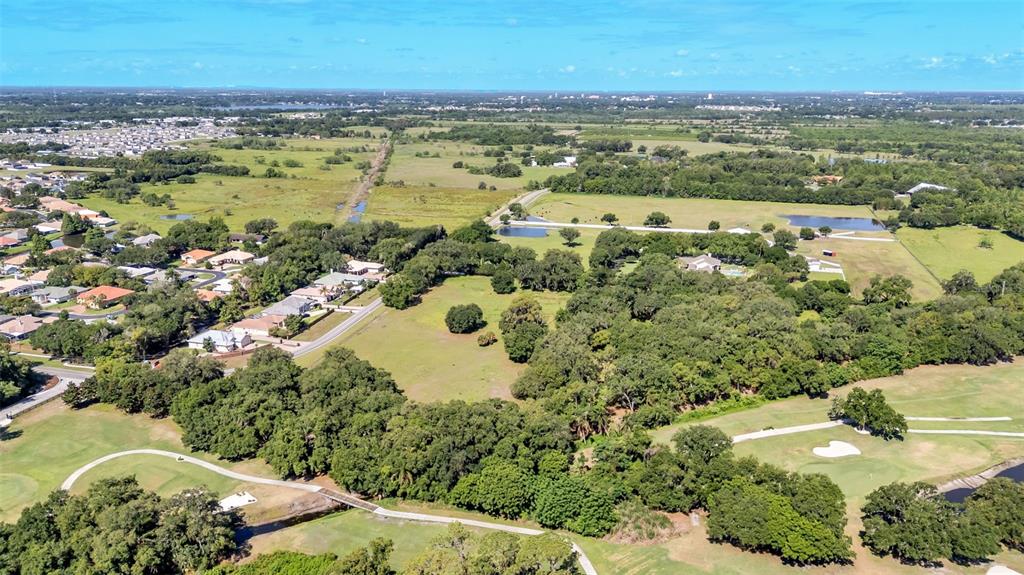An aerial view shows a residential neighborhood bordering a golf course and wooded land — COUNTRY CLUB ROAD S, WINTER HAVEN, FL