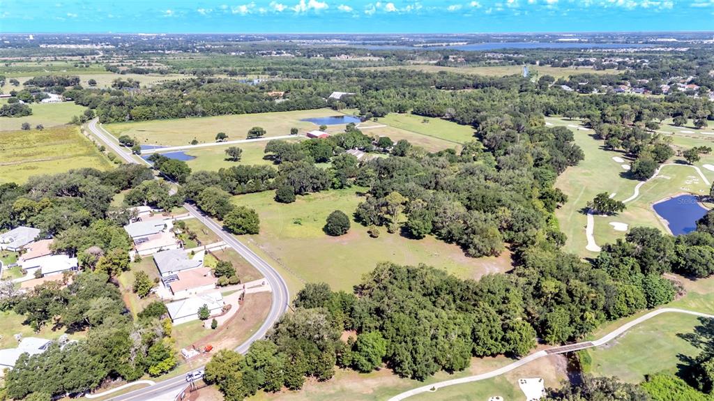 An aerial view shows a residential area with houses, a road, trees, and a golf course — COUNTRY CLUB ROAD S, WINTER HAVEN, FL