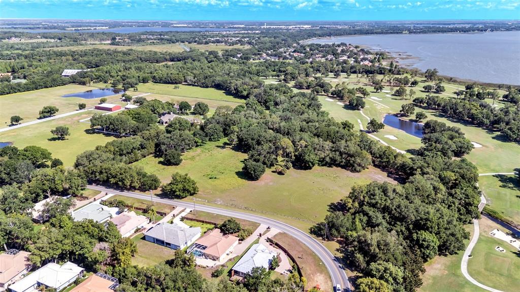An aerial view shows a residential area with houses, a road, and a golf course — COUNTRY CLUB ROAD S, WINTER HAVEN, FL