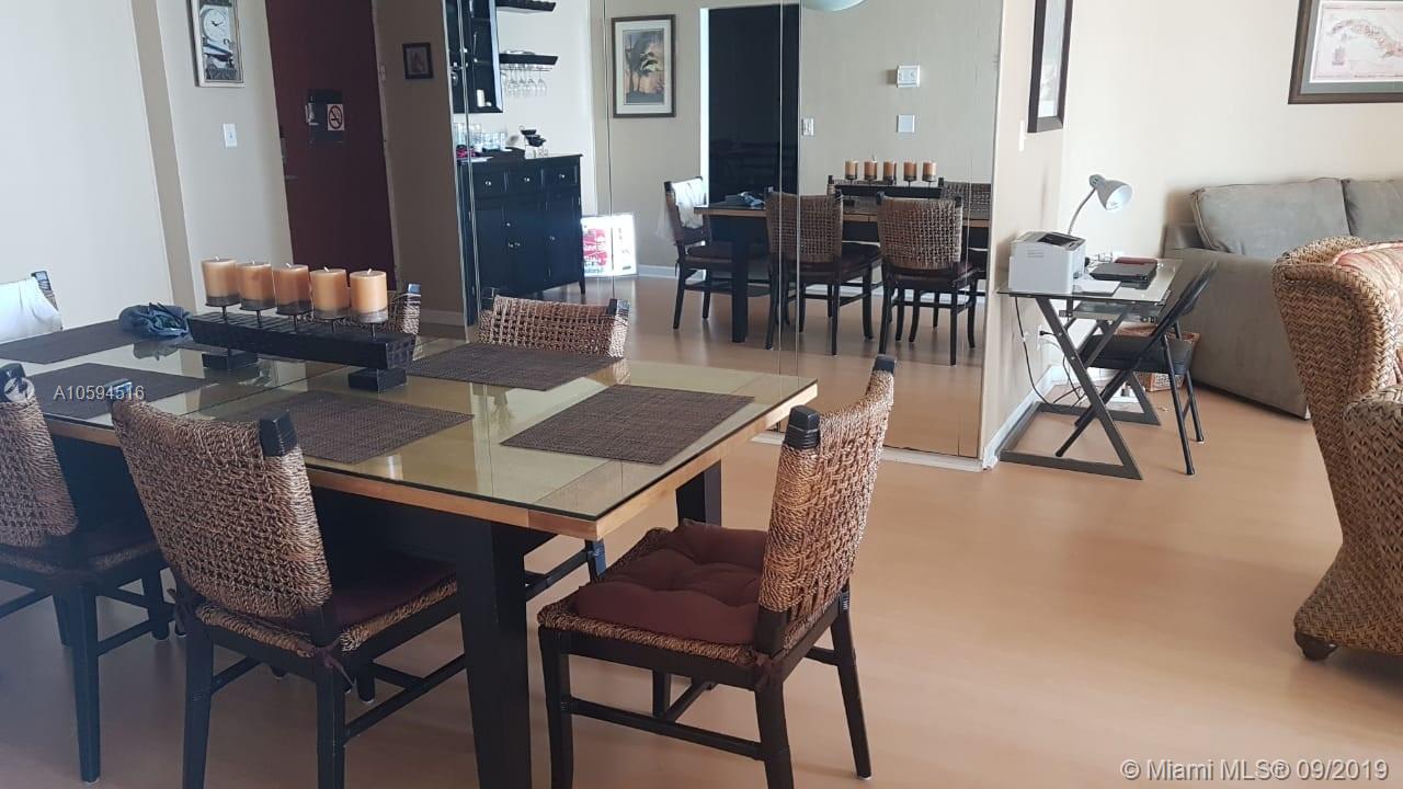 A dining room with a glass table, woven chairs, and a mirrored wall — 3901 S OCEAN DR # 8L, Hollywood FL 33019, HOLLYWOOD, FL